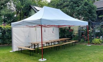 Foto: Eine DRK-Mitarbeiterin spielt 'Mensch ärgere dich nicht' mit einem älteren Herrn. Beide scheinen dabei sichtlich Spaß zu haben und lachen miteinander.